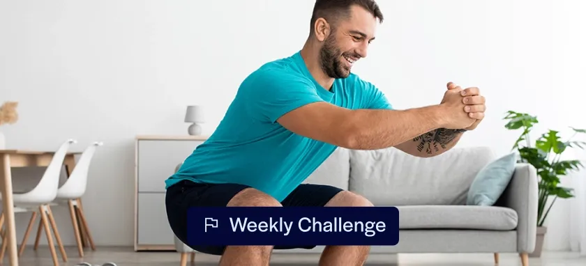 Man doing a squat at home while motivated to exercise