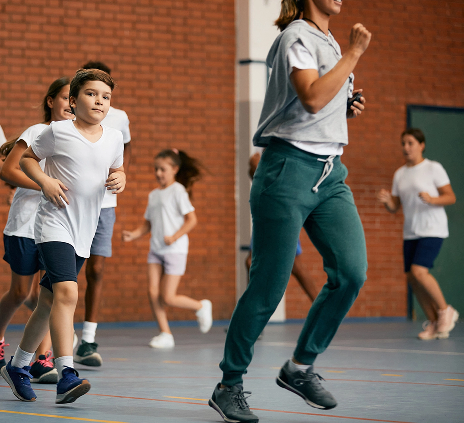 Kids running around the gym in a Physical Education class